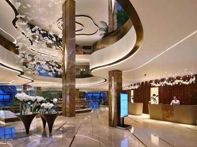 Elegante vestíbulo de hotel con diseño moderno, suelo de mármol y elementos de iluminación elegantes.