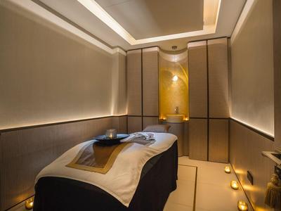 Eleganter Spa-Raum mit Massagebank, gedämpfter Beleuchtung und beruhigenden Kerzen.
