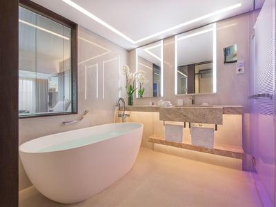 Modernes Badezimmer mit freistehender Badewanne, großem Spiegel und minimalistischem Design.