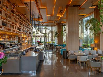 Modernes Hotelrestaurant mit eleganter Beleuchtung, Pflanzen und stilvollen Sitzbereichen.