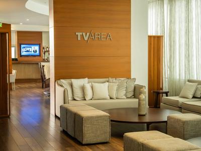 Espace lounge d'hôtel moderne avec canapés beiges et sol en bois