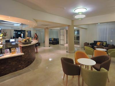 Großer moderner Empfangsbereich mit Rundtheke, Sitzgruppen und warmem LED-Licht.