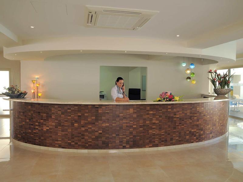 Moderne Rezeption mit rundem Tresen aus braunen Steinen in hellem Empfangsraum.