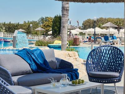 Strefa basenowa z meblami wypoczynkowymi i parasolami w ośrodku hotelowym