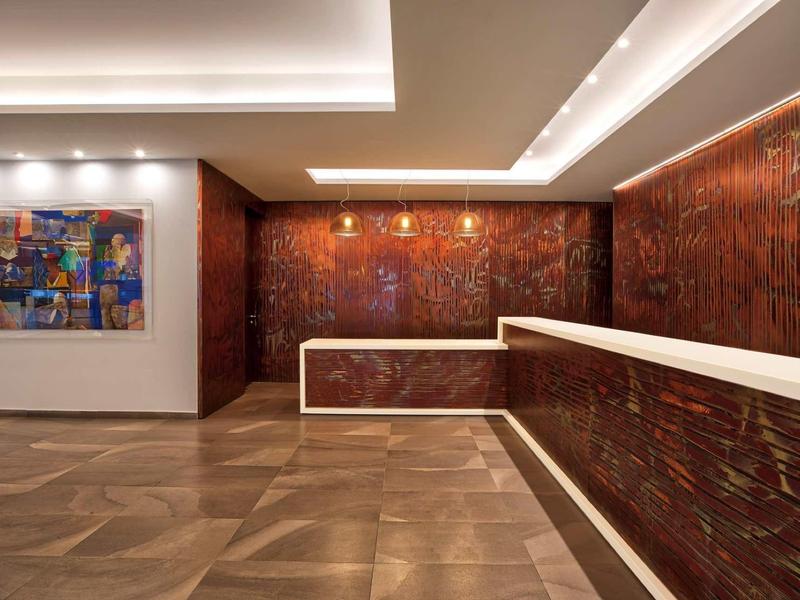 Moderner Raum mit braunem Wandmuster, weißer Theke und farbenfrohem, abstraktem Gemälde an der Wand.