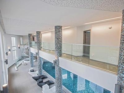 Moderní hotelová chodba se skleněnými zábradlími a stylovými mozaikovými sloupy