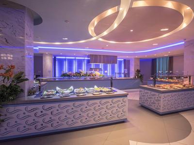 Moderní bufetová stanice v elegantně osvětlené hotelové restauraci s různými pokrmy.