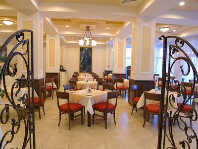 Ristorante elegante con tavoli rotondi, tovaglie bianche e cancelli in ferro decorativi.