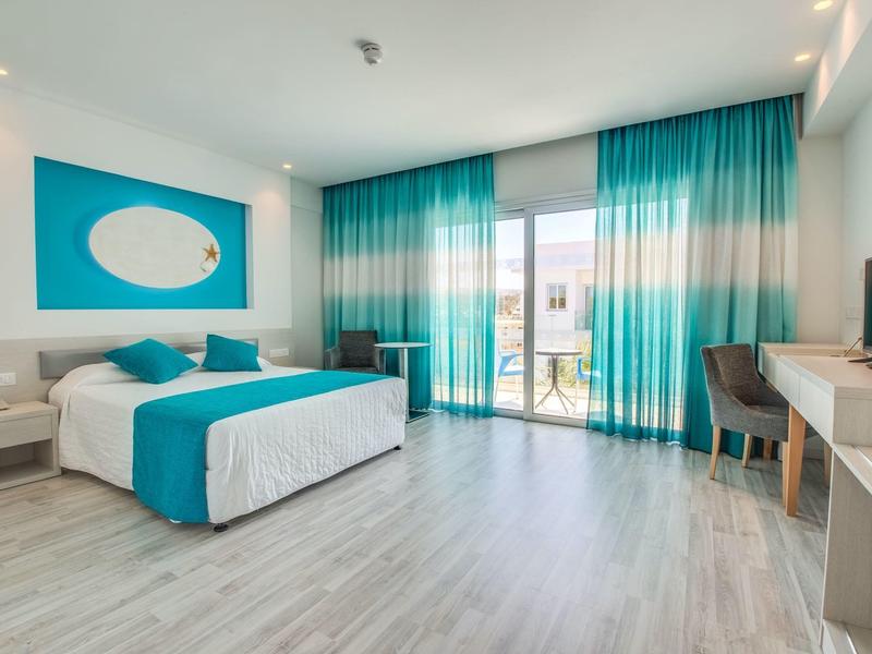 Modernes Hotelzimmer mit Doppelbett, türkisfarbenen Vorhängen und heller Holzbodenfläche.