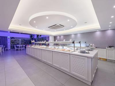 Moderní bufet ve stylové, dobře osvětlené jídelně s bílým nábytkem.