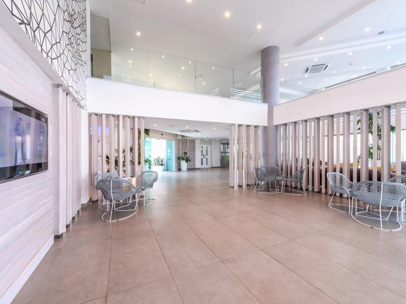 Helles Hotel-Foyer mit modernen Sitzbereichen und großem offenen Raum.