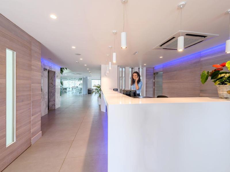 Moderner Hotel-Empfangsbereich mit hellem Tresen und freundlichem Personal