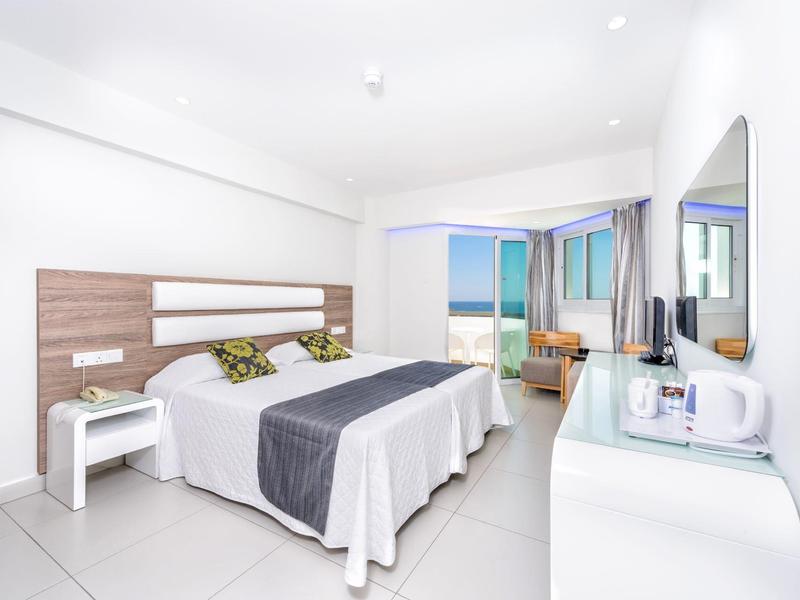 Modernes Hotelzimmer mit Doppelbett, Schreibtisch und Balkon mit Meerblick