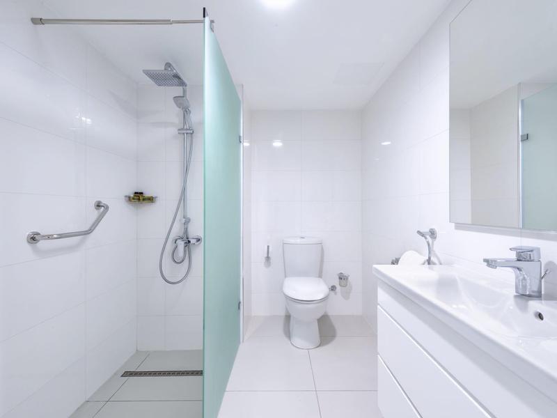 Helles, modernes Badezimmer mit begehbarer Dusche und Doppelwaschbecken.