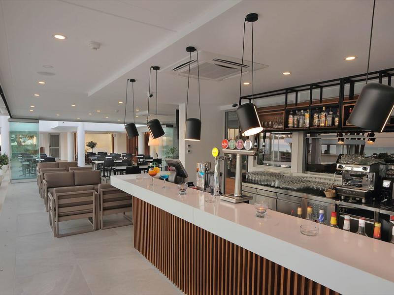 Moderner Hotelbarbereich mit Sitzgelegenheiten und langer Frühstückstheke