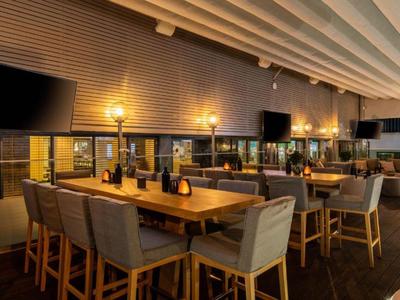 Gemütliche Hotelbar mit Holzmöbeln, bequemen Stühlen und gedämpfter Beleuchtung.