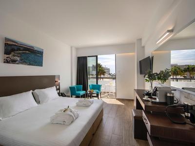 Modernes Hotelzimmer mit Doppelbett, Balkon und Meerblick.