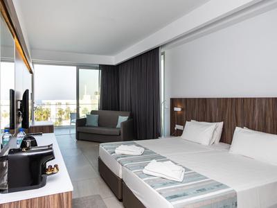 Modernes Hotelzimmer mit zwei Betten, Sitzbereich und großem Fenster mit Ausblick.