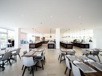 Modernes, helles Hotelrestaurant mit weißen Wänden und stilvollen Sitzbereichen.
