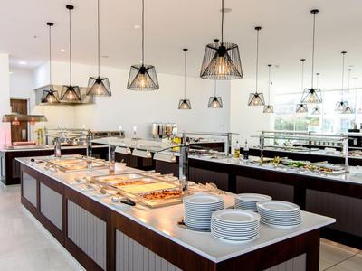 Moderne Hotellobby mit Buffet und stilvollen Pendelleuchten über langen Theken.