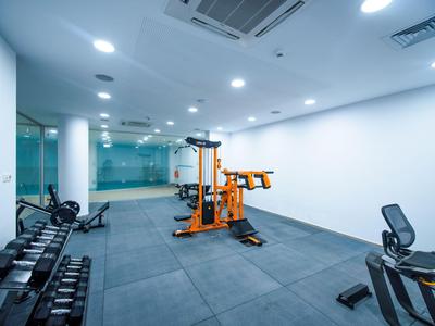 Moderner Fitnessraum in einem Hotel mit Gewichten und Trainingsgeräten.