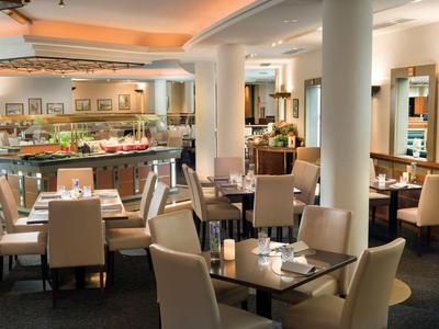 Modern hotel restaurant area with set tables and cozy lighting.