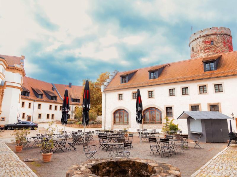 Courtyard of a historic hotel with seating and an illuminated fountain.