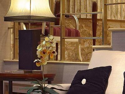 Salon moderne avec canapé, coussins, lampe et fleurs décoratives.