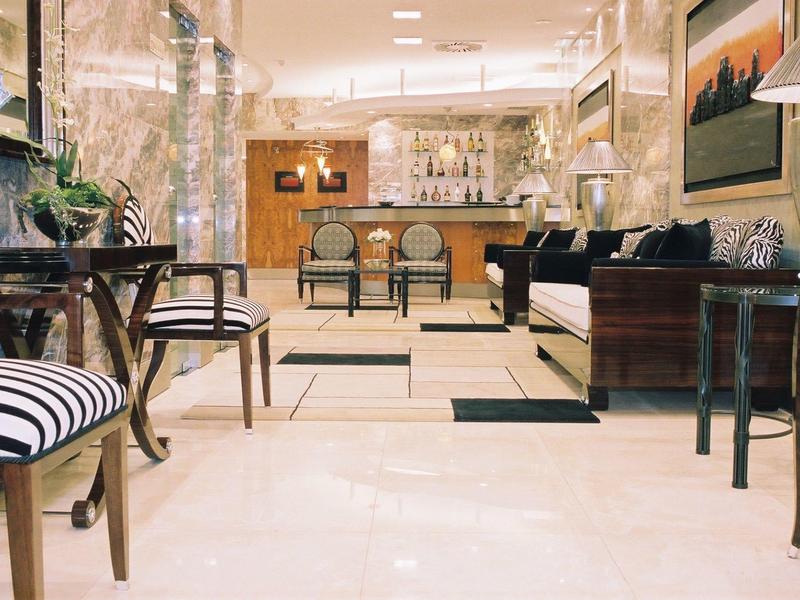 Hall d'hôtel élégant avec sol en marbre, mobilier chic et éclairage chaleureux.