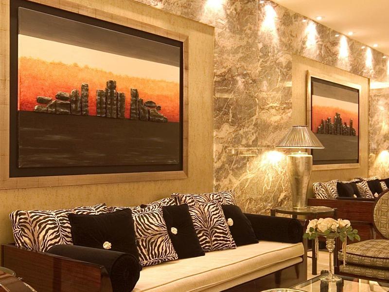 Espace lounge confortable avec canapé, fauteuils, cheminée et vue extérieure en soirée à l'hôtel.