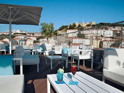 Dakterras met zitplaatsen en uitzicht op de stad bij een blauwe lucht.