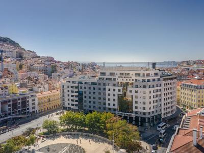 Uitzicht op een hotel in een stad met heuvels en een heldere lucht op de achtergrond.