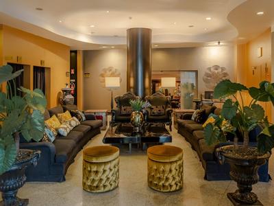 Gezellige hotellobby met banken, planten en zachte verlichting.