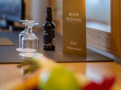 Hotelkamertafel met fles wijn, wijnglas en menu in een elegante omgeving.