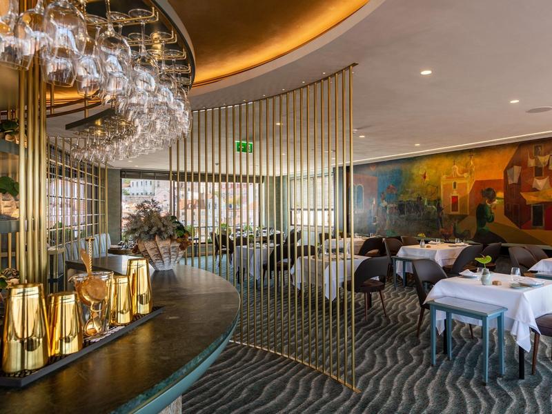 Elegant restaurant met een ronde bar, modern meubilair en sfeerverlichting.