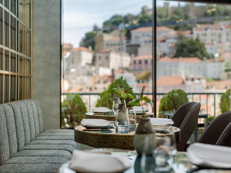 Elegante eetruimte met uitzicht op een stad en heuvels op de achtergrond.