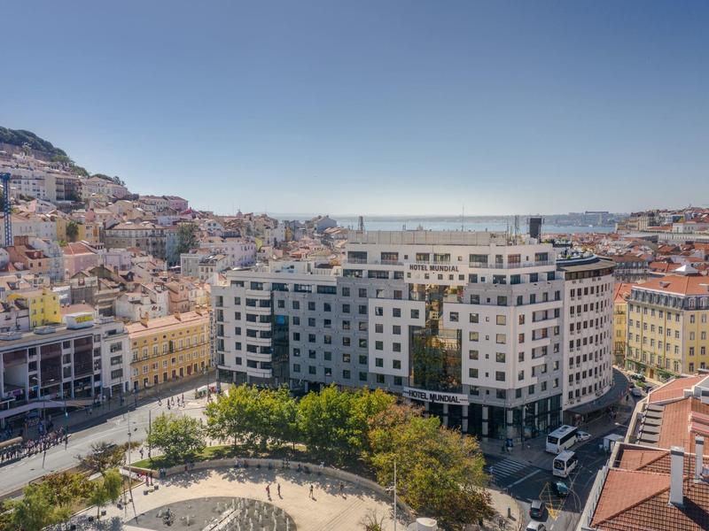 Uitzicht op een hotel in een stad met heuvels en een heldere lucht op de achtergrond.
