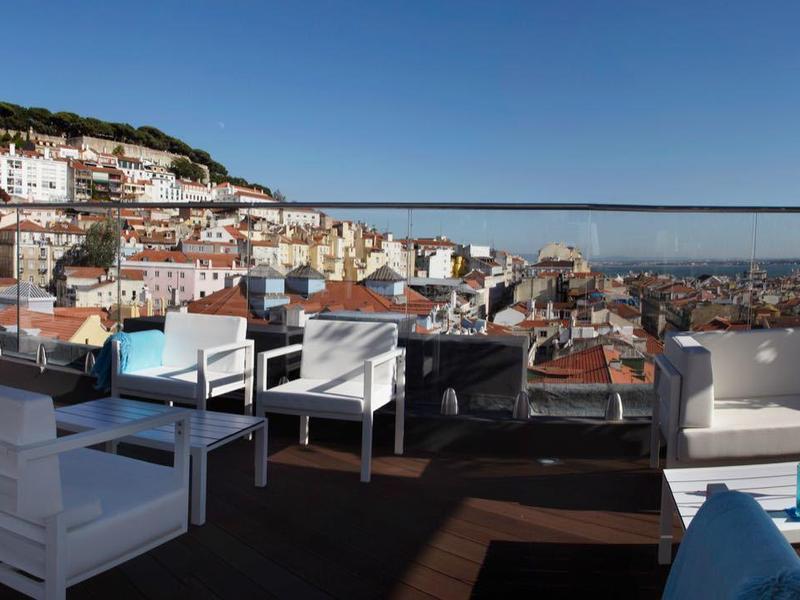 Dakterras met wit lounge meubilair en uitzicht op de stad en rivier bij heldere lucht.