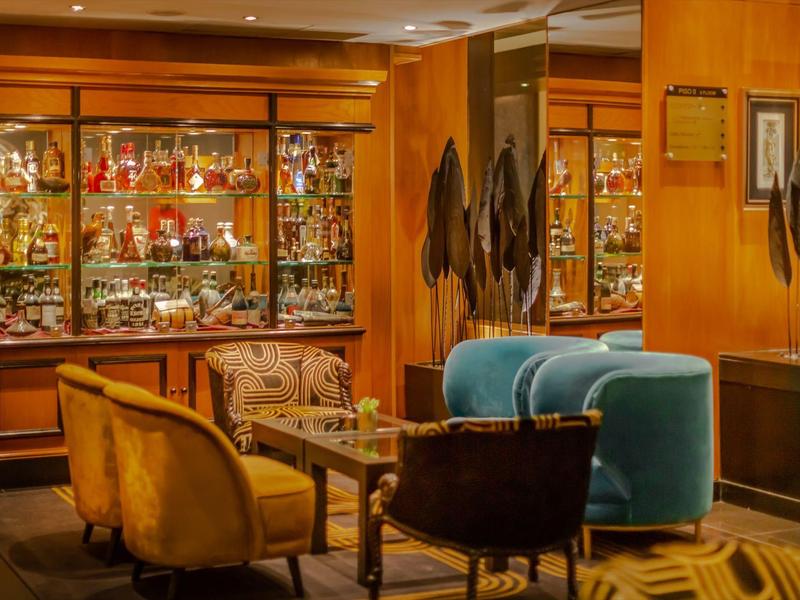 Gezellige hotellounge met kleurrijke zitmeubels en verlichte vitrinekast