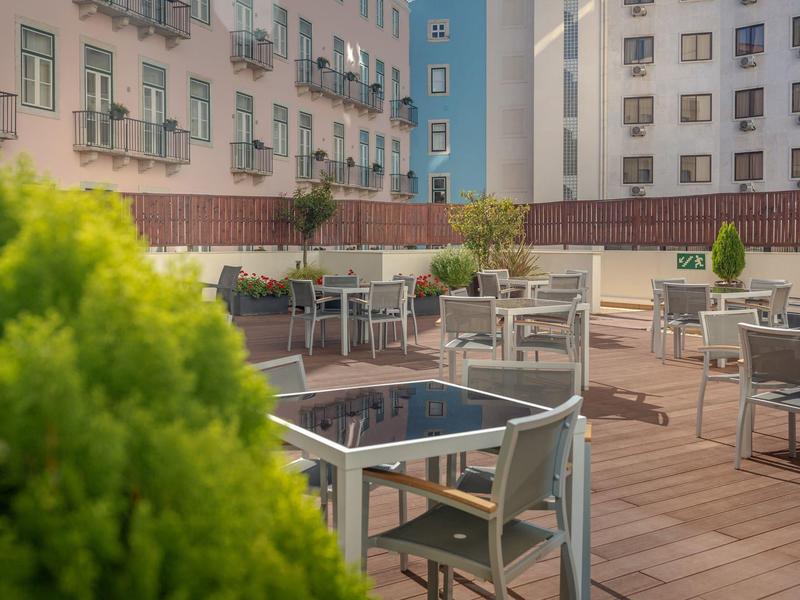 Hotelterras met tafels en stoelen voor meerlaagse gebouwen.