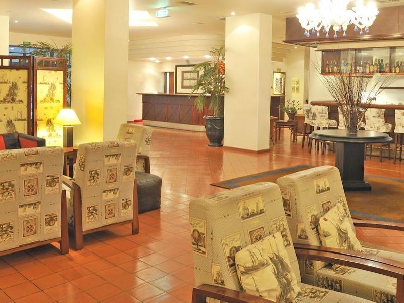 Pohodlná lounge s křesly a dekorativními paravany v hotelové restauraci.