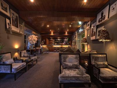 Accogliente area lounge dell'hotel con illuminazione calda e comode poltrone.