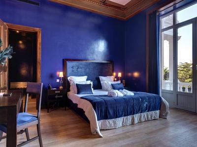 Camera elegante con tema blu, letto matrimoniale e accesso al balcone con vista