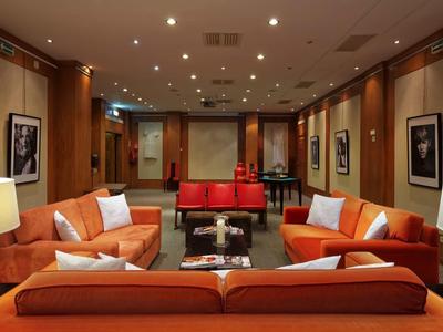 Area lounge moderna con divani arancioni e illuminazione a soffitto