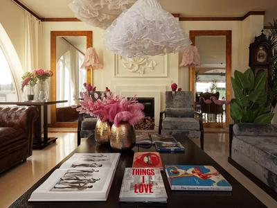 Accogliente soggiorno con divani, libri d'arte e composizioni floreali.