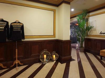 Camera d'hotel con sgabelli, eleganti pannelli in legno e specchi decorativi sulla parete.