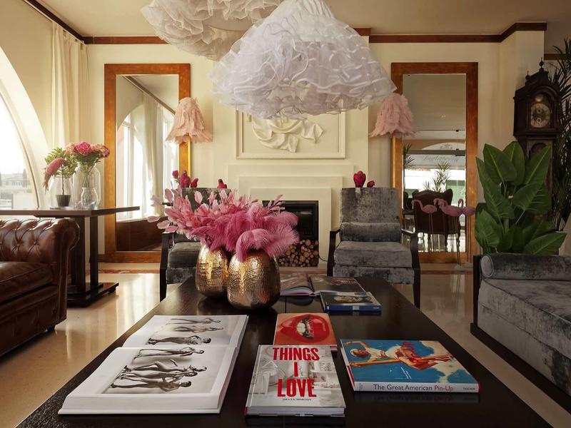 Accogliente soggiorno con divani, libri d'arte e composizioni floreali.