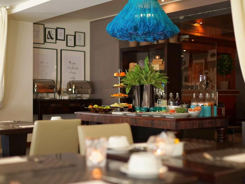 Area colazione moderna con buffet, fiori e decorazione elegante.