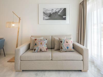 Modern pool area with loungers and green lawn in the background under clear sky.