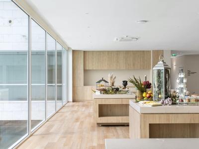 Bright, modern breakfast buffet in a room with large glass wall and wooden floor.